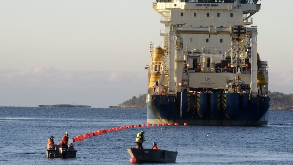 Crew deploying subsea cable from a vessel during marine installation